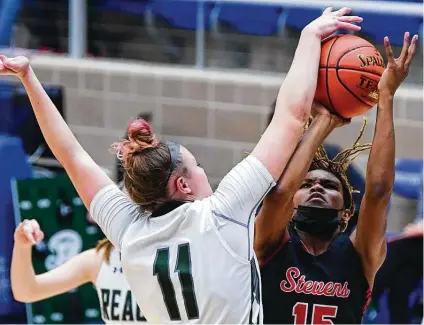  ?? Billy Calzada / Staff photograph­er ?? Reagan’s Samantha Wagner (11) blocks a shot attempt from Stevens’ Semaj Adams during Friday night’s regional semifinal playoff game at Northside Gym. Wagner posted 22 points and a game-high 19 rebounds for the Rattlers.