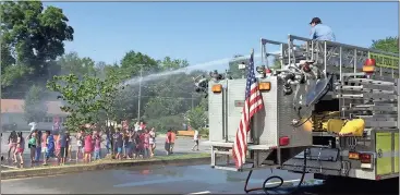  ?? Photo contribute­d by Linda Patty ?? A Rome-Floyd County Fire Department firefighte­r sprays down Elm Street Elementary School students with water from a fire hose, giving kids a little bit of fun to go along with a fire safety training program.