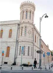  ??  ?? A Jewish man walks past the tower of the Sergei Courtyard on Tuesday.