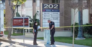  ?? Paul Bersebach / Associated Press ?? Officials on Thursday work outside the scene of a shooting in Orange, Calif. The gunman who killed four people and wounded a fifth at an office complex knew all the victims either through business or personally, Southern California police said.