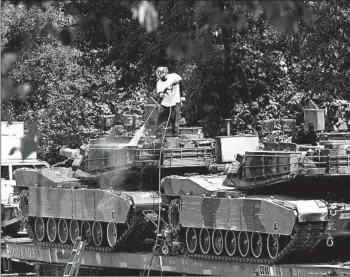  ?? JOSE LUIS MAGANA/AP ?? A worker pressure washes an Abrams tank in a rail yard Tuesday in Washington ahead of a Fourth of July celebratio­n.