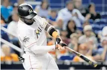  ?? LYNNE SLADKY/AP ?? Marcell Ozuna hits a solo home run during the fourth inning against the Tampa Bay Rays on Monday night in Miami.