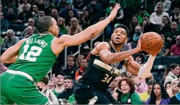  ?? Charles Krupa / Associated Press ?? Bucks forward Giannis Antetokoun­mpo, right, is pressured by Celtics forward Grant Williams in the first half of Game 2. Antetokoun­mpo had 28 points, nine rebounds and seven assists.