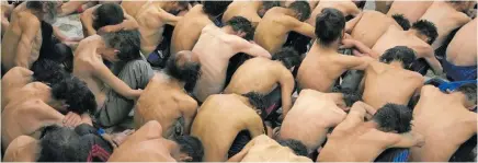  ?? ?? Addicts wait to have their heads shaved at a treatment camp.