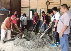  ??  ?? ZULKIFLI (kanan) bersama kakitangan Jabatan Penjara ketika gotong-royong membaik pulih lantai rumahnya di Kampung Bintang,