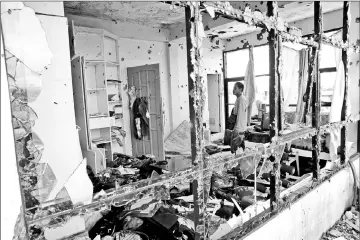  ?? — Reuters photo ?? A member of the local town security forces inspects a damaged room in an apartment house in Malutlut district, Marawi city, southern Philippine­s, which was believed to have been rented by Hapilon and Omar Maute before their battle in Marawi city.