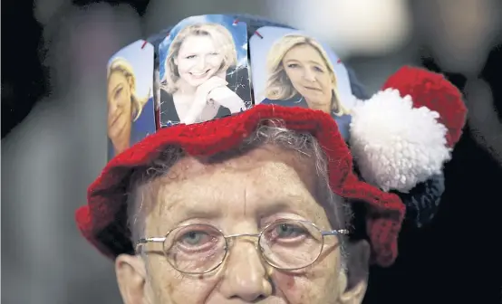  ?? REUTERS ?? A supporter wears a hat with pictures of Marine Le Pen, right, and Marion Marechal-Le Pen, centre, French National Front political party candidates for the second round of regional elections in Marseille, France, on Wednesday. Marine Le Pen’s election...