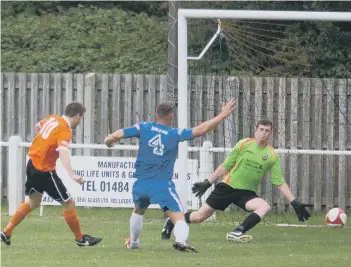  ??  ?? Tom Matthews slots the ball home to put Brighouse Town ahead in their 2-1 success over Radcliffe Borough