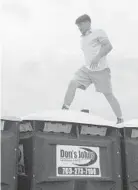  ?? COLIN CAMPBELL/BALTIMORE SUN ?? A man who declined to give his name runs across the top of port-a-potties in the Preakness Infield. A friend, Sam Cook, who also did it, called the feeling “absolutely exhilarati­ng.”