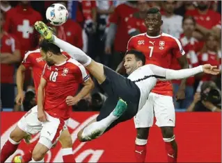  ?? FRANK AUGSTEIN, THE ASSOCIATED PRESS ?? France’s Adil Rami, right, goes for the ball as Switzerlan­d’s Admir Mehmedi tries to stop him during Sunday’s match, which ended in a 0-0 draw. France’s coach complained about the state of the soccer pitch.