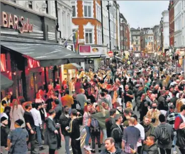  ??  ?? LET LOOSE: Revellers pack a street outside bars in the Soho area of London as Covid-19 restrictio­ns were further eased on Saturday.
AFP