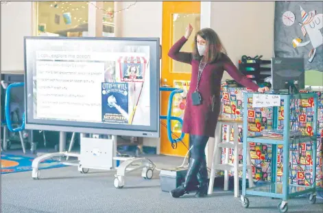  ?? (Arlington Heights Daily Herald/Brian Hill) ?? Lauren Blanford, Emerson Elementary School librarian, records an online session in Elmhurst, Ill. Blanford brought her boundless energy to online library programs and all the other changes wrought by the past year of the pandemic.