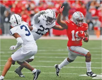  ?? AP PHOTO/JAY LAPRETE ?? Ohio State running back Chip Trayanum carries the ball for the Buckeyes during Saturday’s Big Ten matchup against previously unbeaten Penn State. Ohio State won 20-12 to remain undefeated.