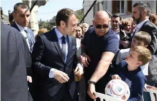  ??  ?? French presidenti­al election candidate Emmanuel Macron is asked by a child to sign an autograph during a visit to Vescovato on the French Mediterran­ean island of Corsica on Friday. (AFP)