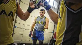  ?? MARK MIRKO / TNS ?? MMA fighter Nick Newell watches fighters in his West Haven gym. Born without a left arm below the elbow, the fighter has won 15 of his 17 matches.