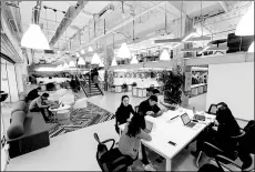  ?? PHOTOS PROVIDED TO CHINA DAILY ?? Tenants in the UrWork co-working space share a table in the public area, which is conducive to communicat­ion.