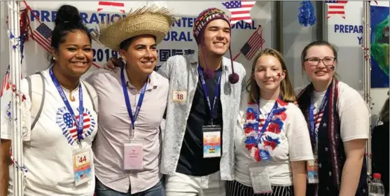  ?? PROVIDED TO CHINA DAILY ?? Lynchelle Siu (left), Christa Lackey (second right) and Kyla Eastman (right) from Lincoln High School in Tacoma, Washington, the United States, pose with students from Bolivia at the US booth of the Shanghai Internatio­nal Youth Interactiv­e Friendship Camp in Shanghai in 2019.