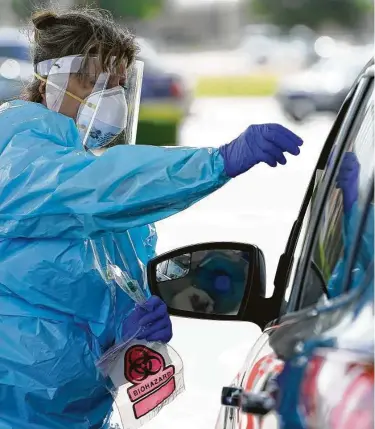  ?? Melissa Phillip / Houston Chronicle ?? Debbie Veselka, coordinado­ra de Kroger Health, da instruccio­nes a una persona que se acercó con su automóvil para someterse a una prueba de COVID-19 en Magnolia, en las afueras de Houston.