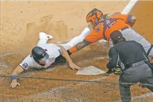  ?? JIM MONE/ASSOCIATED PRESS ?? The Twins’ Max Kepler, left, beats the tag by Astros catcher Martin Maldonado to score in the third inning in Game 1 of an American League wild-card series Tuesday in Minneapoli­s.