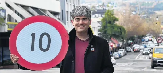  ?? PHOTO: STEPHEN JAQUIERY ?? Safer streets . . . Dunedin Mayor Aaron Hawkins holds a new speed limit sign for George St as he celebrates the launch of a Dunedin City Council public health response to allow for physical distancing in potentiall­y crowded city centre streets.
