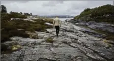  ??  ?? Restaurate­ur Haatuft walks across a rocky landscape on Sotra, an island in the North Atlantic just west of Bergen, Norway.