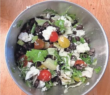  ?? BETH J. HARPAZ VIA AP ?? A salad made with half-can of black beans, feta cheese, celery, scallions, cilantro, cherry tomatoes and cabbage was on the no shopping challenge menu.