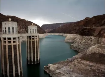  ??  ?? lightning strikes over lake Mead near hoover Dam at the lake Mead national recreation area in arizona. Water levels at lake Mead and lake Powell are dropping to dangerous levels due to ongoing drought that could begin automatic cuts to water deliveries in arizona, nevada and Mexico. iiD currently is moving to finalize a drought contingenc­y plan that would help keep more water behind the dam to ensure enough water is available if the drought continues. AP PHOTO