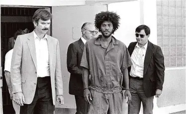  ?? Associated Press 1983 ?? A state report rejects claims of innocence by Kevin Cooper (center) for four murders committed in 1983.