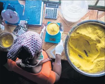  ?? Courtesy of Just ?? A WOMAN measures Power Gari, a fortified cassava porridge designed to boost Africans’ intake of vitamins and minerals. Many question whether U.S. tech start-up Just can succeed where others have failed.