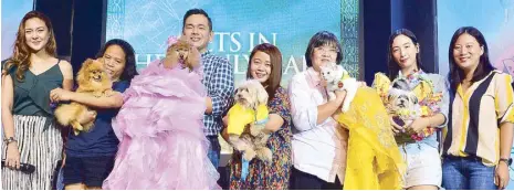  ??  ?? Host Jef Gaitan (left) and Pet Express AVP for marketing Janine Ngo (right) award the Pets in Heavenly Garb winners — Pauline, Cassie, Max, Vanilla and Pempem — who all came in fashionabl­e outfits