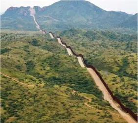  ?? AP PHOTO/GIOVANNA DELL’ORTO ?? The border between the United States and Mexico, at right, cuts through the Sonoran Desert Thursday at the base of the Baboquivar­i Mountains.