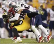  ?? JARED WICKERHAM — THE ASSOCIATED PRESS FILE ?? In this file photo, Pittsburgh Steelers running back Le’Veon Bell (26) is tackled by New England Patriots strong safety Patrick Chung (23) during the second half of an NFL football game in Pittsburgh. The Steelers and Patriots meet in the AFC...