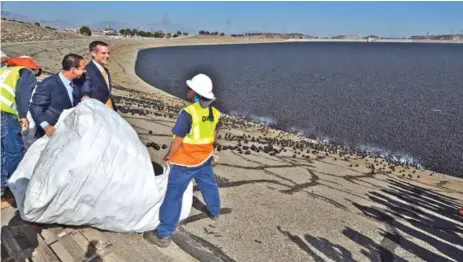  ??  ?? Los Angeles Mayor Eric Garcetti dumps a bag of “Shade balls” into the L.A. reservoir in August 2015.