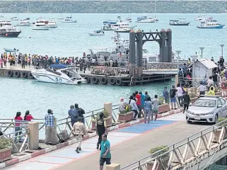  ?? PHOTO COURTESY OF ROYAL THAI NAVY ?? Onlookers observe the rescue work for the Phoenix dive boat at Chalong Bay in Phuket.