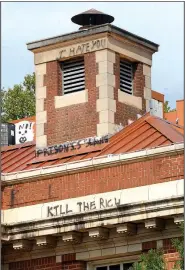  ?? NWA Democrat-Gazette/DAVID GOTTSCHALK ?? Graffiti is visible Monday on the south-facing side of The Old Post Office building in the center of the square in Fayettevil­le. Words and markings, including profanity, are visible on other areas of the building.