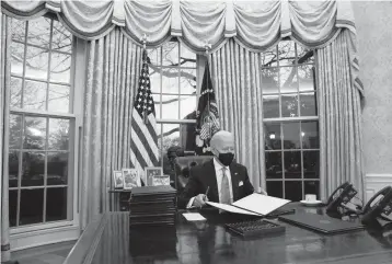  ?? EVAN VUCCI/AP ?? President Joe Biden signs a series of executive orders on Inaugurati­on Day at the White House in Washington.