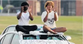  ?? STEPHEN M. DOWELL/ORLANDO SENTINEL ?? Attendees cheer from atop their car during a March For Our Lives Florida drive-in rally and aid event Friday at Tinker Field in Orlando. The event was held to speak out against Gov. Ron DeSantis’ protest bill, HB 1.