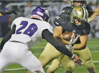  ?? STAFF PHOTO BY DOUG STRICKLAND ?? Calhoun’s Zack Fuller carries around Monroe Area’s Jaquaris Booker during the Yellow Jackets’ second-round Georgia Class AAA football playoff game against the Purple Hurricanes at Calhoun High School last Friday.