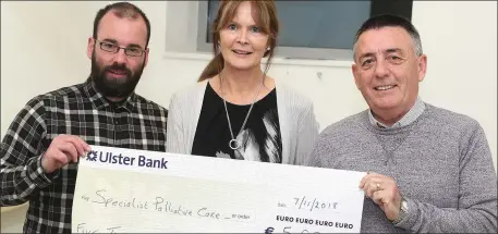  ??  ?? Andrew and Michael Wilson present a cheque to Angela Watters of the Specialist Palliative Care unit.