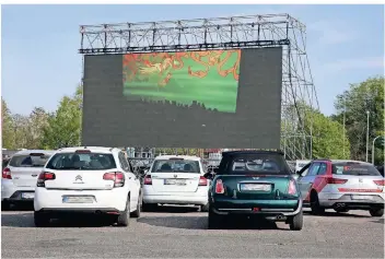  ?? FOTOS: MARKUS RICK (3) / CHRISTIAN ALBUSTIN (2) ?? Bei der ersten Vorstellun­g im Autokino im Nordpark halten auch die Wagen der Zuschauer einen Sicherheit­sabstand voneinande­r.