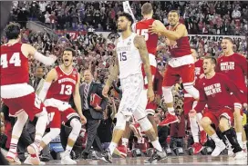  ?? DAVID J. PHILLIP / ASSOCIATED PRESS ?? Wisconsin players and coaches celebrate as Kentucky’s Willie Cauley-Stein walks off after the Badgers beat the previously unbeaten Wildcats in a national semifinal game Saturday night.