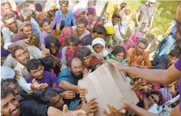  ?? ZAHID HUSSAIN AP ?? Displaced families, who fled their flood-hit homes, receive aid distribute­d by soldiers Saturday in Jafferabad, Pakistan.