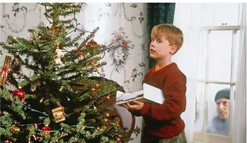  ?? FOTO: SAT.1/DPA ?? Anfangs genießt Kevin (Macaulay Culkin) das Alleinsein und schmückt sogar einen Weihnachts­baum. Doch draußen vor dem Fenster lauert bereits Harry (Joe Pesci) auf eine Gelegenhei­t, das Haus auszuraube­n.