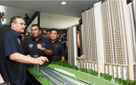  ??  ?? Building a future: Hishammudd­in looking at a model of affordable apartment units for armed forces personnel and the Defence Ministry’s civilian staff at the army camp in Sungai Besi. — Bernama