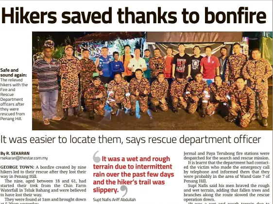  ??  ?? Safe and sound again: The relieved hikers with the Fire and Rescue Department officers after they were rescued from Penang Hill.