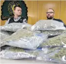  ??  ?? RCMP Const. Kerry Whitbread, left, and Saanich Police Const. Drew Hildred with bags seized in a drug bust near Swartz Bay.