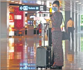  ?? AFP/ FILE ?? A Singapore Airlines stewardess returns from a flight at Changi Internatio­nal Airport.