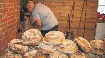  ?? FOTO: FRANZ DREHER ?? Einen heißen Arbeitspla­tz hatten die fleißigen Helfer beim Heizen und „Einschieße­n“der vielen Brotlaibe.