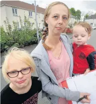  ??  ?? Family under threat Michelle Carroll signs the petition as kids Kacie and Walker look on