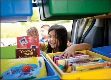  ?? NWA Democrat-Gazette/JASON IVESTER ?? Amy Peraza, 8, chooses a book during the mobile library’s stop at the playground on Commons Avenue in Springdale. Sonora Elementary School — and other schools throughout Northwest Arkansas — started the program to keep students reading during the...